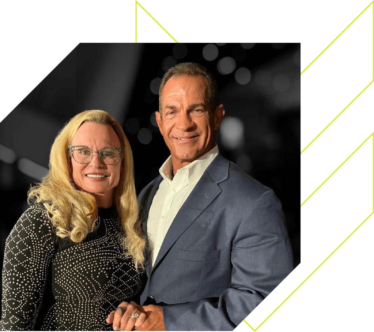 Man and woman posing together against a black background with geometric design elements.