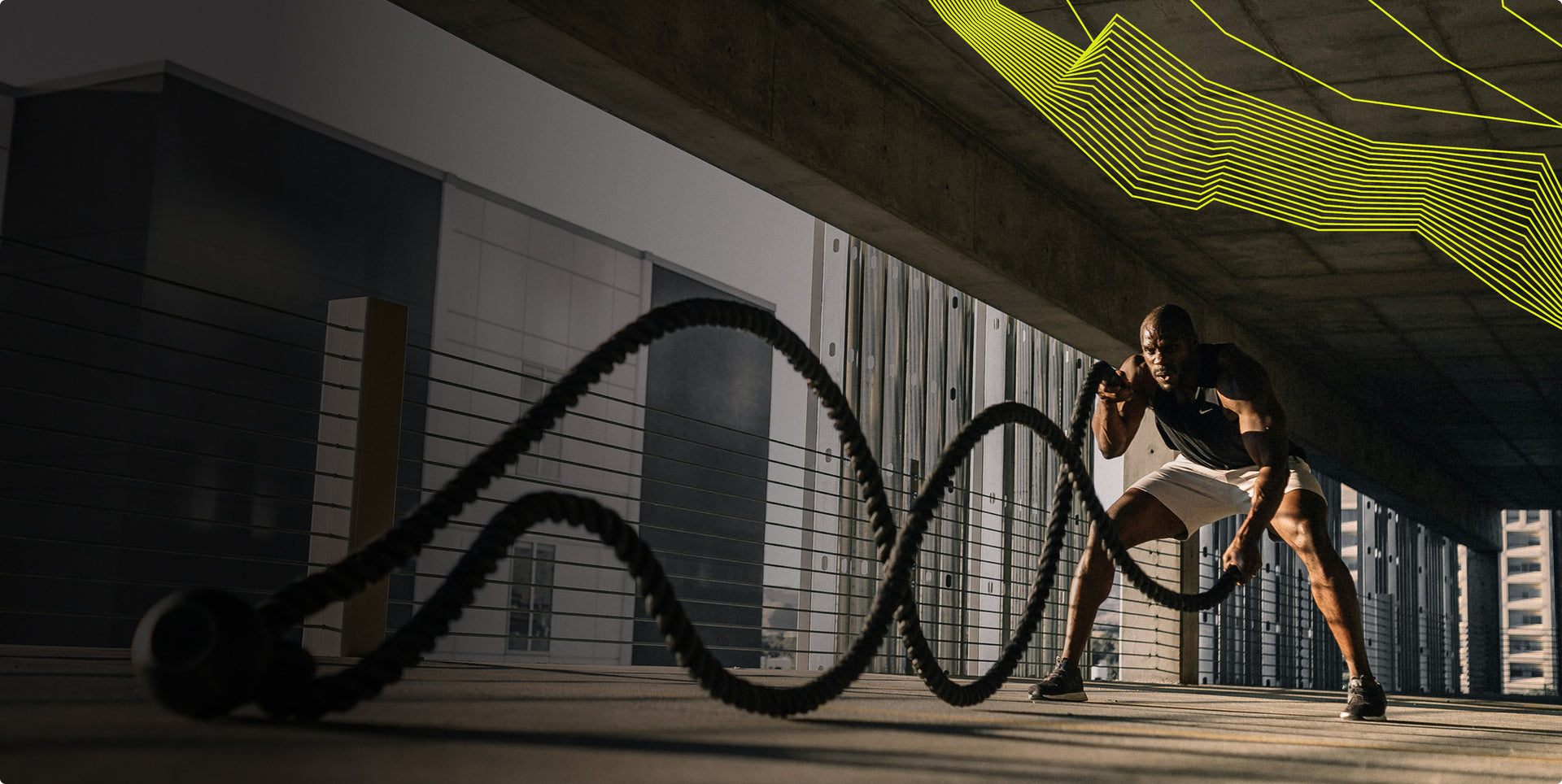 Person using battle ropes in an urban setting with modern buildings in the background