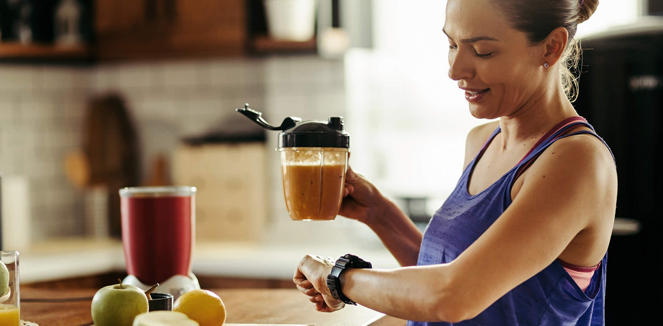 Woman holding a glass of iced coffee in a kitchen setting